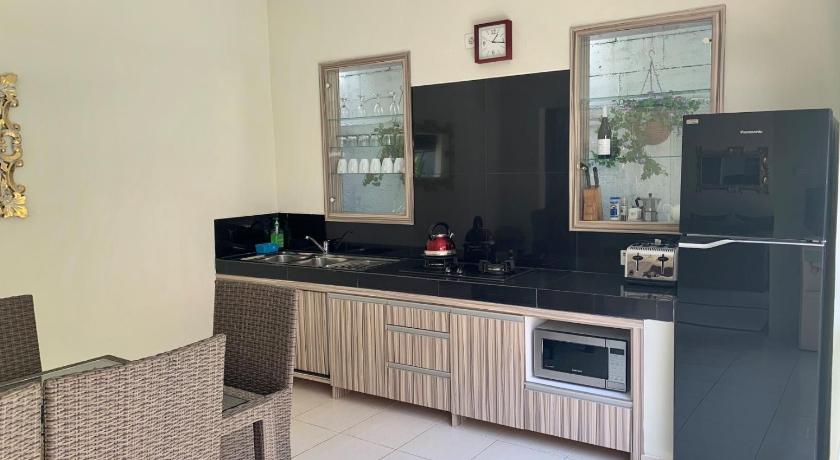 a kitchen with a refrigerator, sink, and dishwasher, Villa Bahagia in Bali
