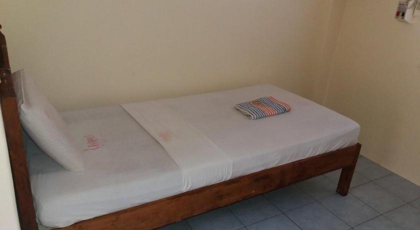 a bed sitting in a room next to a wall, Eco Pension in Surigao City