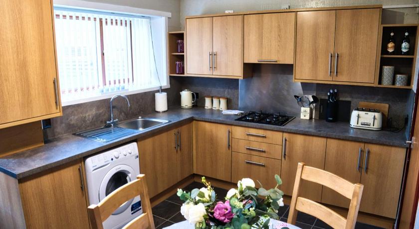 a kitchen with a stove a sink and a dishwasher, North Coast House in Thurso