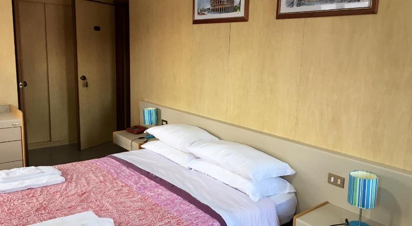 a hotel room with a bed and a desk, hotel socrate in Lavena Ponte Tresa
