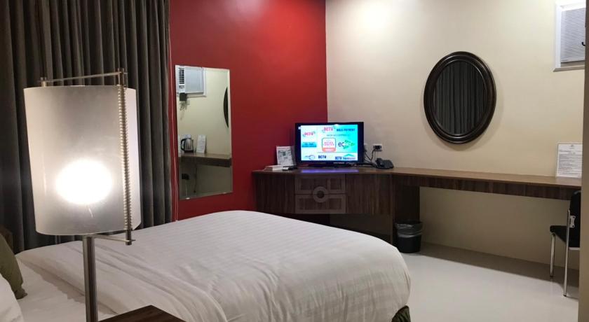 a hotel room with a bed, desk and television, Dreamwave Hotel Polangui in Legazpi