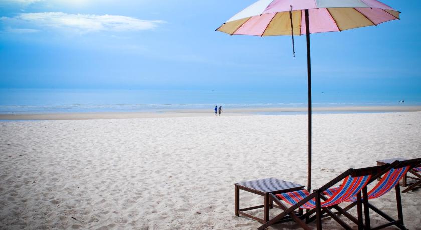 a beach umbrella sitting on top of a sandy beach, Tara Mantra Cha-Am Resort in Hua Hin / Cha-am