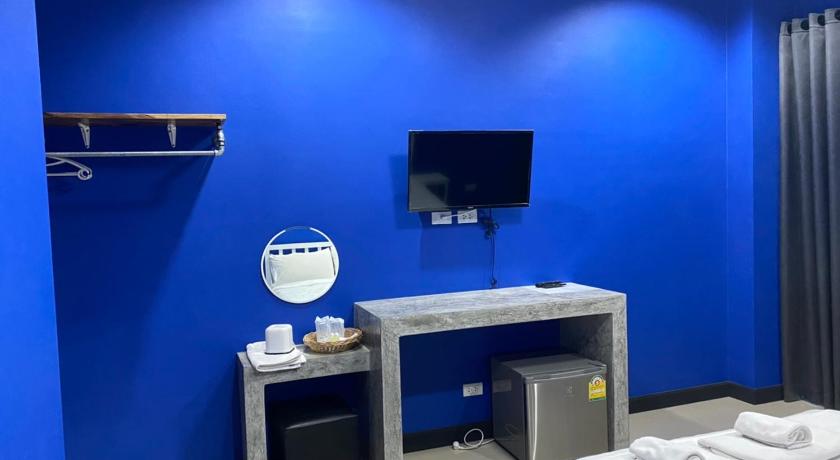 a bathroom with a television and a blue wall, SAVE ZONE in Phetchaburi