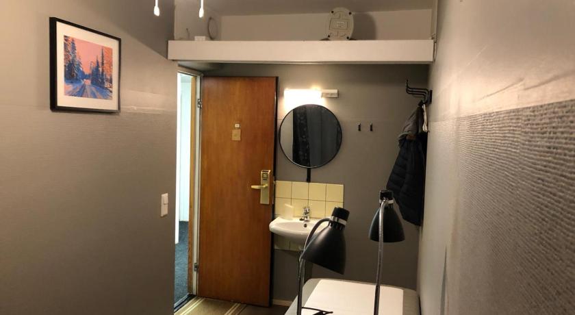 a bathroom with a sink and a mirror, Hostel Matkakoti Patria in Lahti