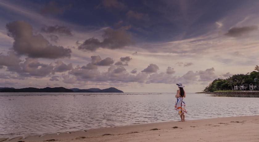 a woman standing on a beach next to a body of water, Rebak Island Resort and Marina Langkawi in Langkawi
