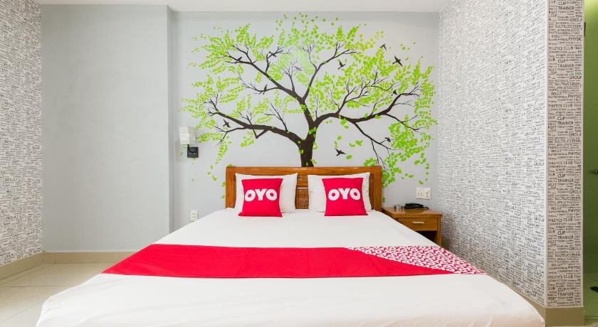 a bed with a white bedspread and pillows in a room, OYO 701 Avatar 6 Hotel in Ho Chi Minh City