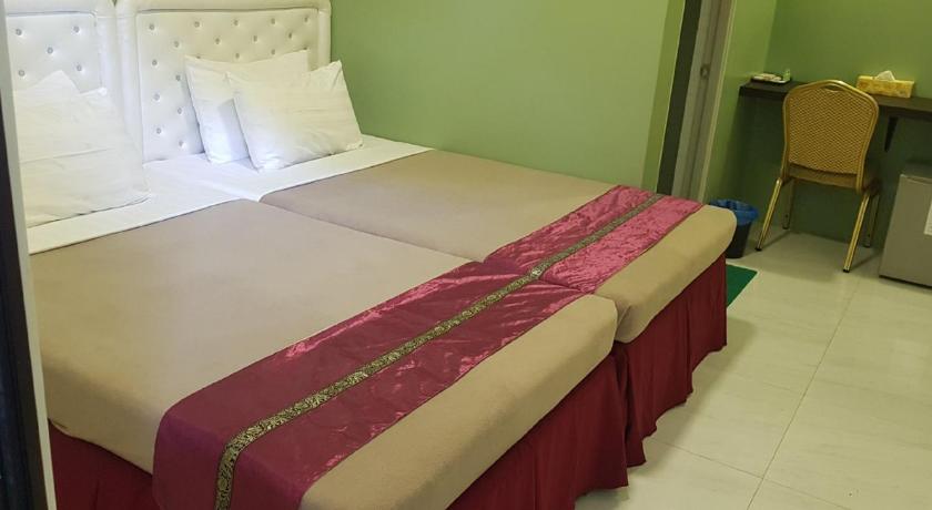 a bed that has a red blanket on top of it, Supreme Hotel in Yangon
