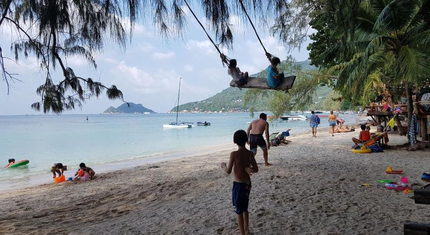 a young boy standing on top of a sandy beach, In Touch Resort in Ko Tao