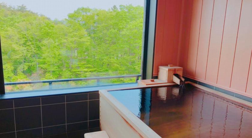 a white toilet sitting in a bathroom next to a window, Kajitsu no Mori in Ichinoseki