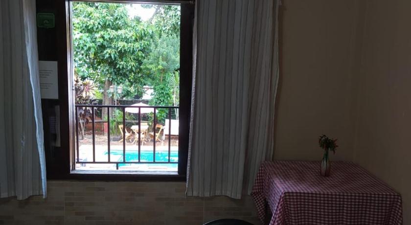 a room with a bed, table and window, El Guembe Suites in Puerto Iguazu