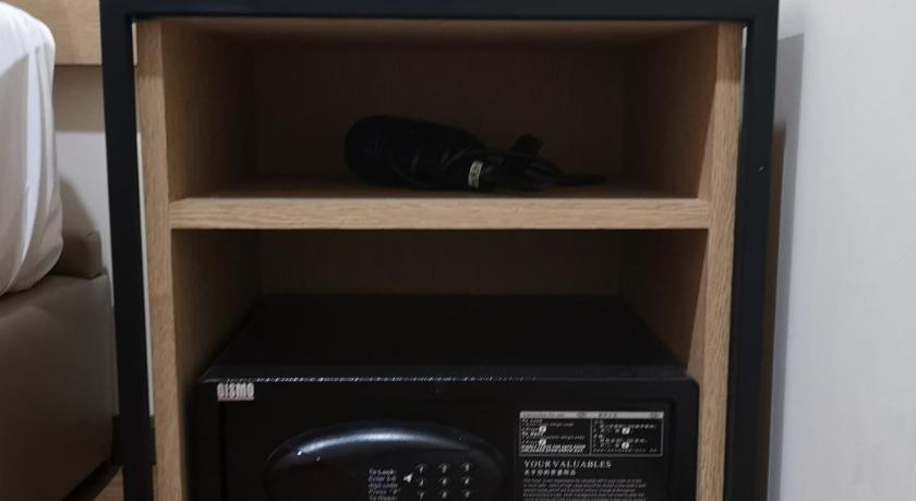 a black microwave sitting on top of a wooden shelf, Qlio Hotel in Kota Kinabalu