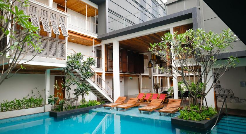 a swimming pool with a large green plant in front of it, Nanda Heritage Hotel in Bangkok