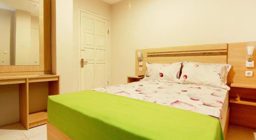 a bedroom with a bed and a desk, Homestay HD Inn in Yogyakarta