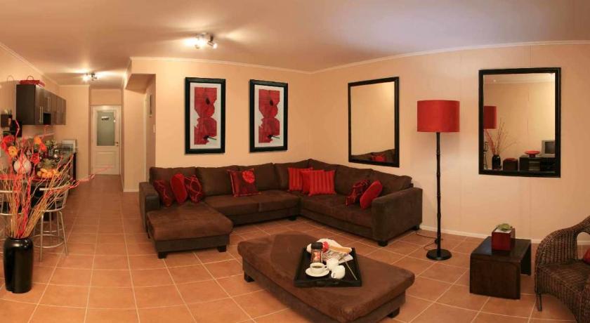 a living room filled with furniture and a couch, La Loggia Gateway Apartments in Durban