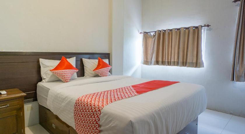 a hotel room with two beds and two lamps, OYO 2598 Hotel Chocolate in Lhokseumawe