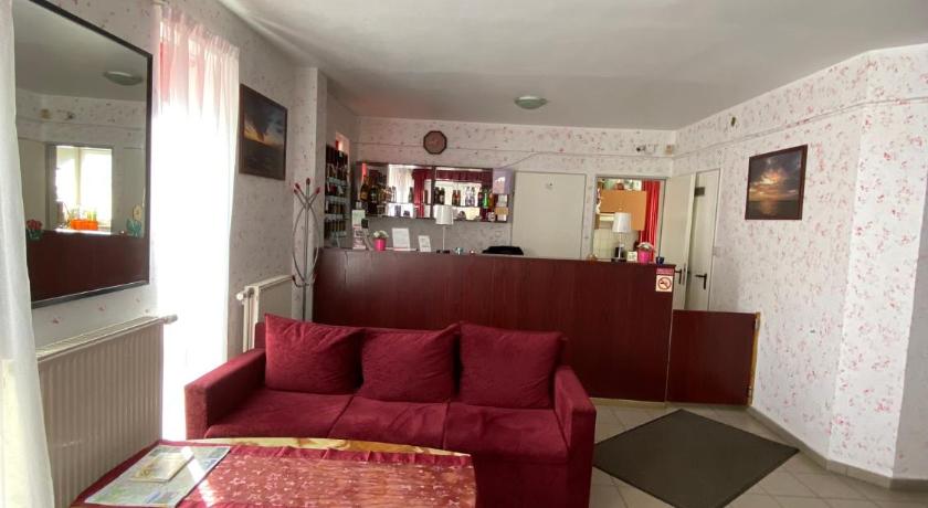 a living room filled with furniture and a red couch, Panama Motel in Szekesfehervar