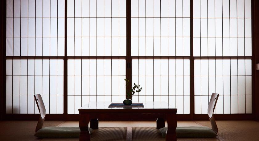 a room with a table, chairs and a window, Tsukasaya Ryokan in Tsuruoka