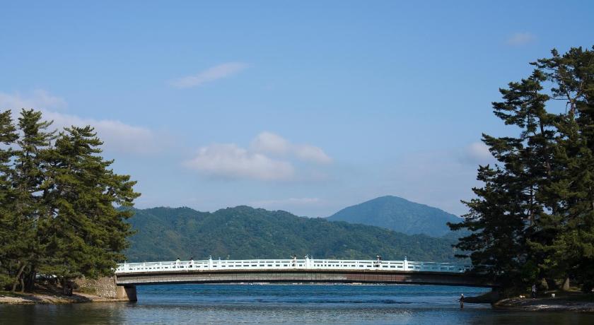 a bridge over a river with a train on it, Shourotei Hotel in Miyazu