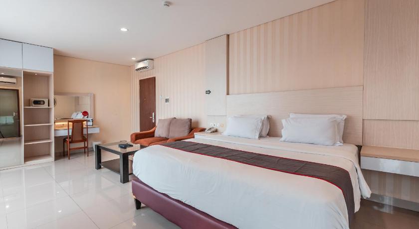 a hotel room with a bed and a desk, Collection O 26 Hotel Igloo in Cikarang