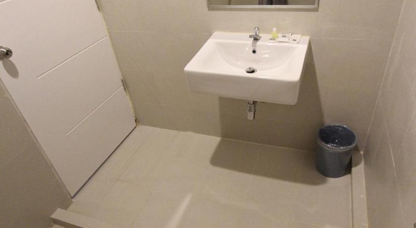 a bathroom with a sink, toilet and mirror, Rajthani Hotel (SHA Extra Plus) in Surat Thani