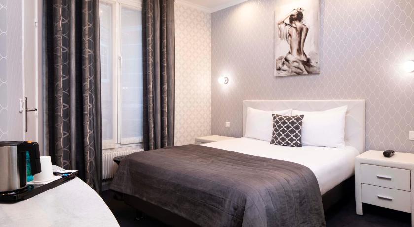 a hotel room with a bed and a dresser, Hotel de Geneve in Paris