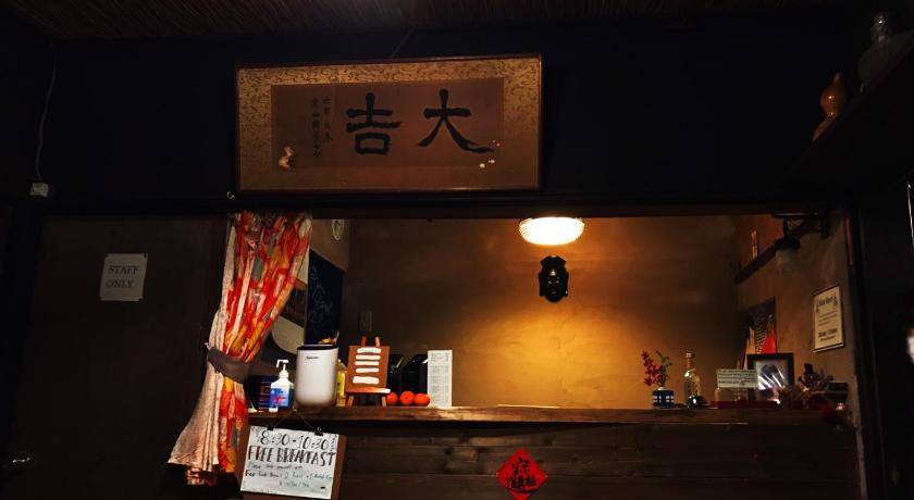 a person standing at a counter in a restaurant, Hostel Mundo in Kyoto