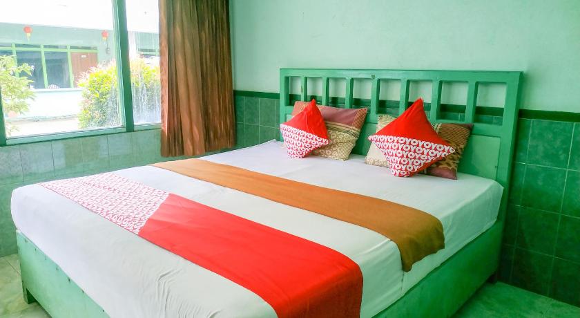 a bed room with two beds and a window, Super OYO 3098 Hotel Sahabat Baru in Singkawang