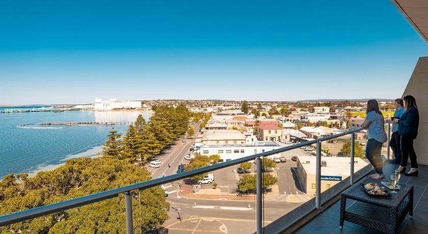 a person sitting on a balcony looking out over the water, Port Lincoln Hotel in Port Lincoln