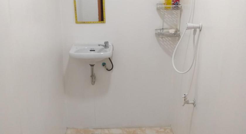 a bathroom with a toilet, sink, and mirror, Casa de Corazon Native House For Rent in Bohol