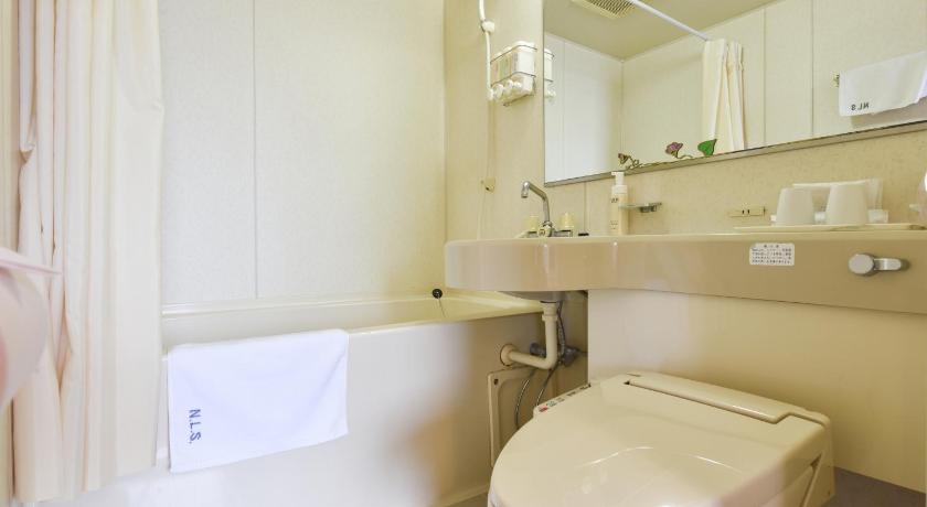 a white toilet sitting next to a white sink, Hotel Hana in Takayama