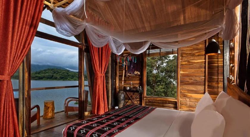 a hotel room with a balcony overlooking the ocean, Lak Tented Camp in Buon Ma Thuot