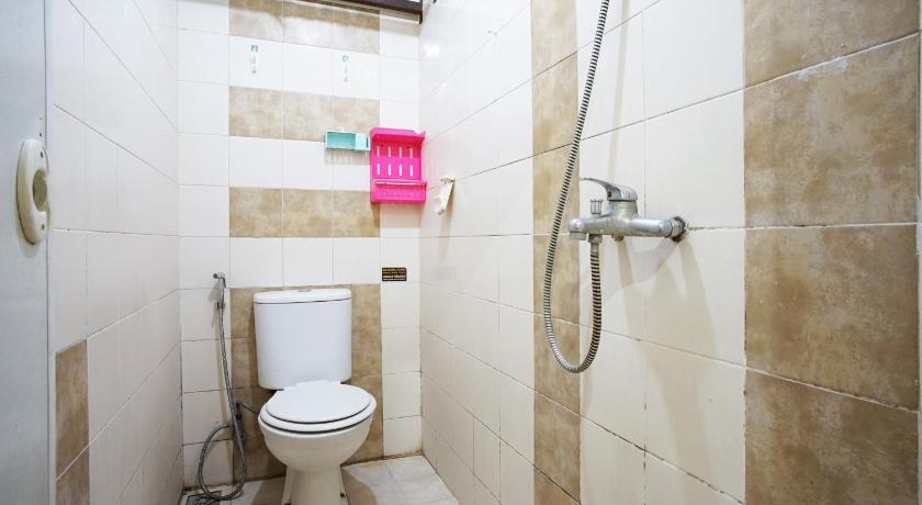 a bathroom with a toilet and a shower stall, Kamarku Apartment in Bandung