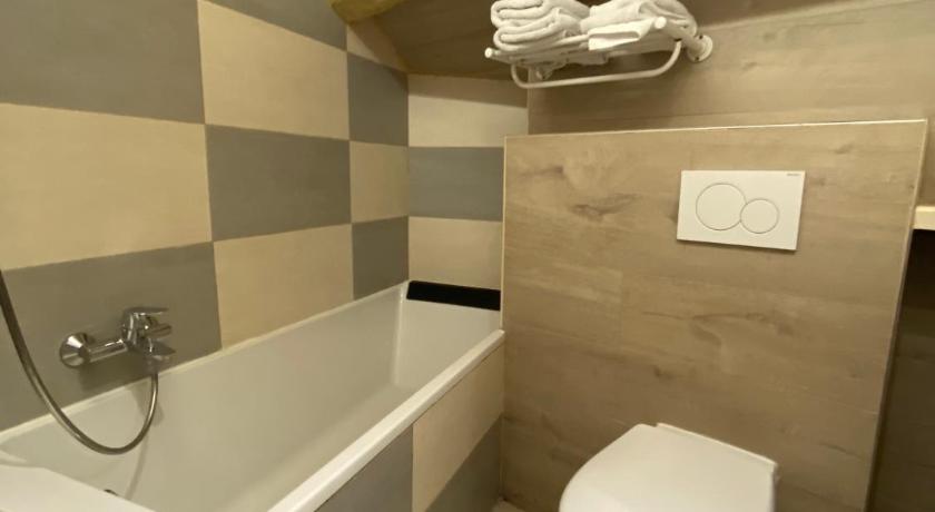 a white toilet sitting next to a bath tub, Le Strasbourg Hotel in Montpellier