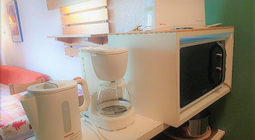 a kitchen with a microwave and a coffee maker, Residence Chanteneige - Freeloc Immobilier in Saint-Martin-de-Belleville