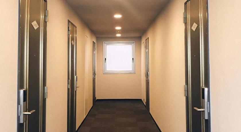 an empty room with a door open, Nissin Namba Inn in Osaka