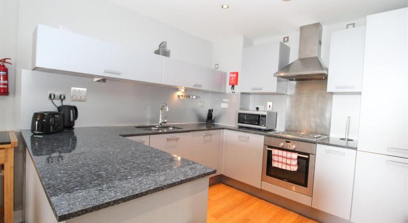 a kitchen with a stove top oven and a sink, Dreamhouse Apartments Glasgow City Centre in Glasgow