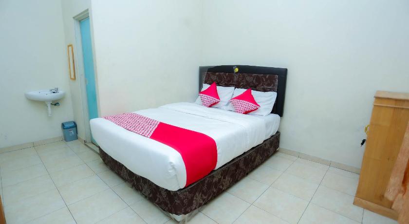 a bed with white sheets and pillows in a room, OYO 2692 Penginapan Mba Ros in Banjarbaru