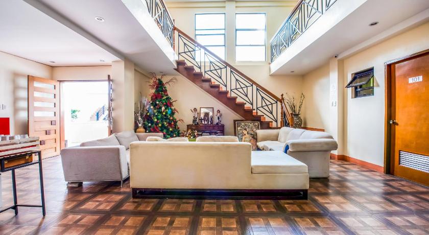 a living room filled with furniture and a staircase, Capital O 494 Modern Peak Suites & Resorts in Antipolo