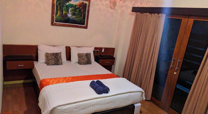 a hotel room with a bed and a table, Indah Nusantara in Banyuwangi