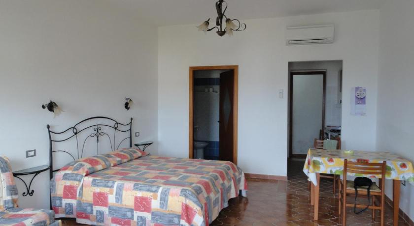 a bedroom with a bed, table and chairs, Cavadozza in Ponza Island