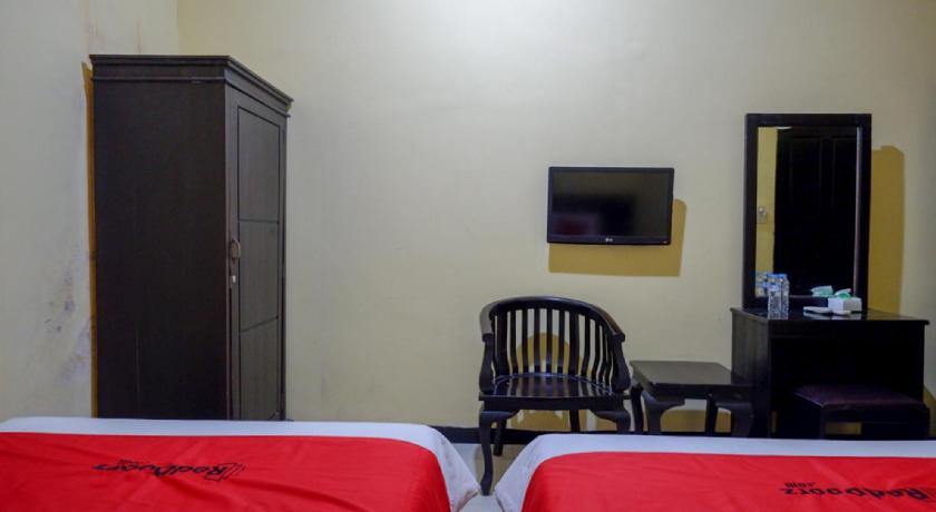 a hotel room with two beds and a television, RedDoorz near Citraland Waterpark Kendari in Kendari
