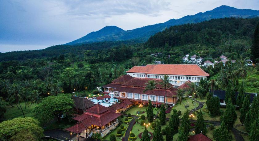 a house with trees and a mountain range, Royal Trawas Hotel & Cottages in Trawas