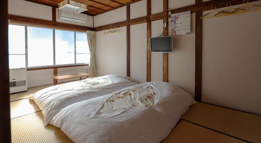 a bedroom with a bed and a window, Fujiyoshida Youth Hostel in Fujikawaguchiko