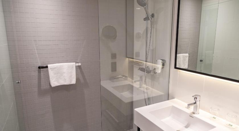 a bathroom with a sink, mirror, and towel rack, Holiday Inn Helsinki Expo in Helsinki