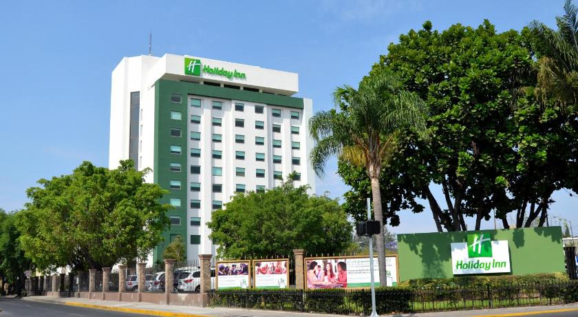 a large building with a clock on the side of it, Holiday Inn Guadalajara Expo in Guadalajara