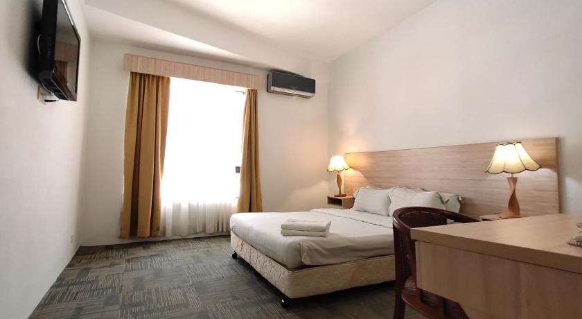a hotel room with a bed and a dresser, Prima Hotel Melaka in Malacca