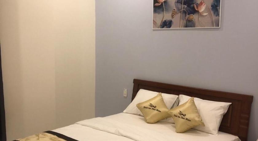 a hotel room with a bed and a lamp, Khai Hoan Hotel in Pleiku (Gia Lai)