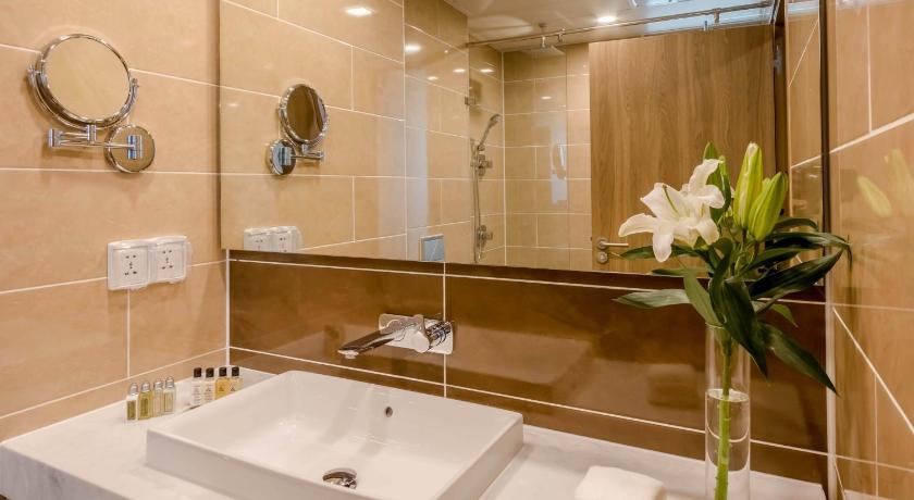 a bathroom with a sink, mirror, and tub, Holiday Inn Ulaanbaatar in Ulaanbaatar