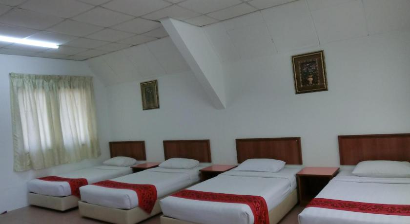 a hotel room with two beds and two lamps, K T Beach Resort in Kuala Terengganu