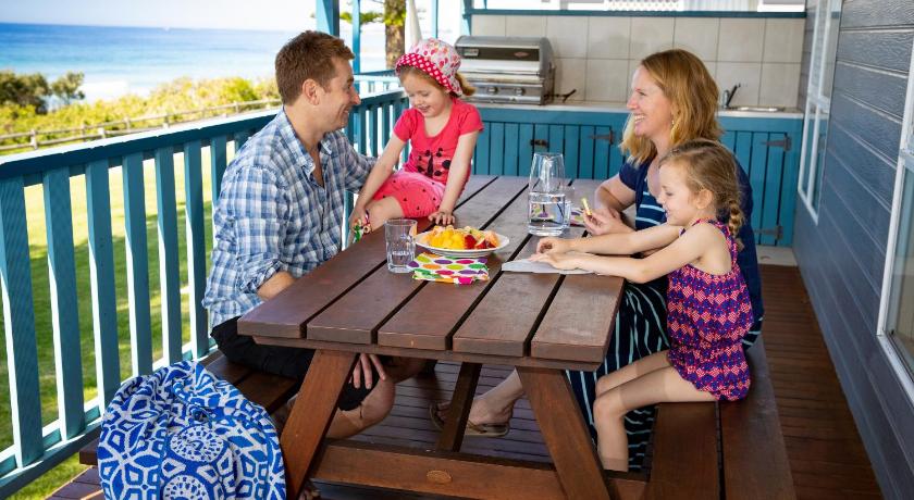 a family sitting at a picnic table, Bulli Beach Tourist Park in Bulli